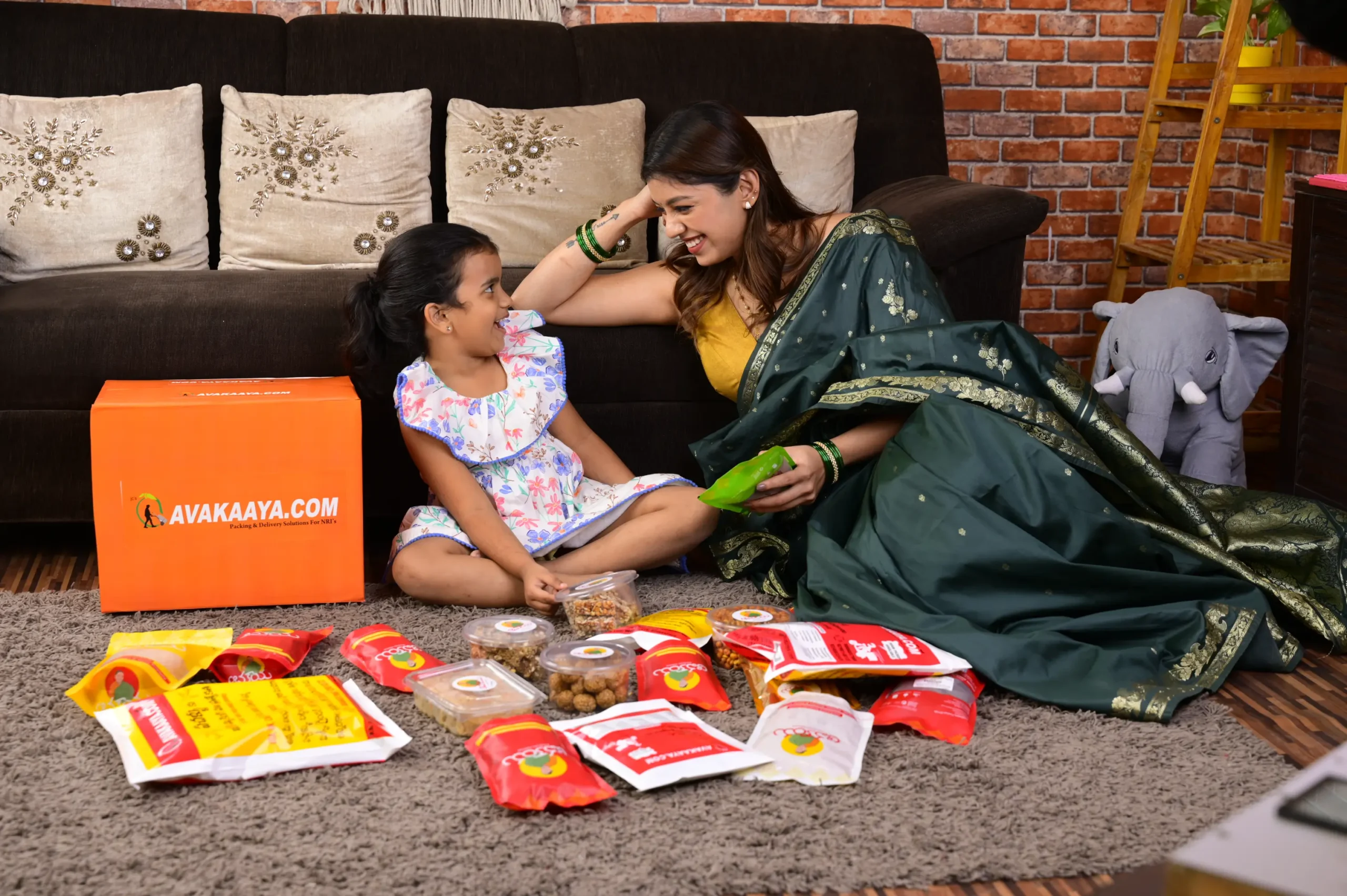 Mother and daughter enjoying snacks from AVAKAAYA.COM box, representing best logistics company offering trusted logistics solutions.